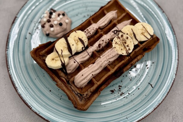 Brownie-Waffel mit Schokodrops, Banane, Schokosahne und Knusperperlen